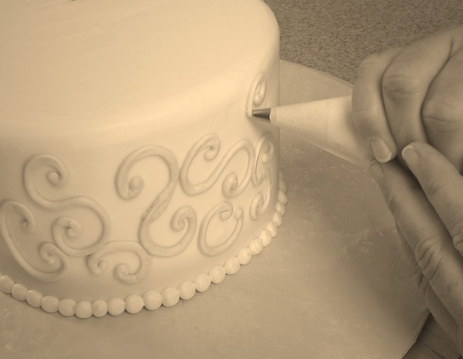 Decorazione di una torta con la sac à poche (foto illustrativa)