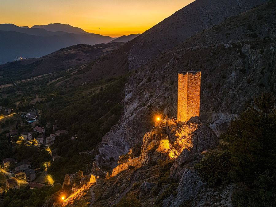 La torre medievale di Roccapreturo illuminata al tramonto
